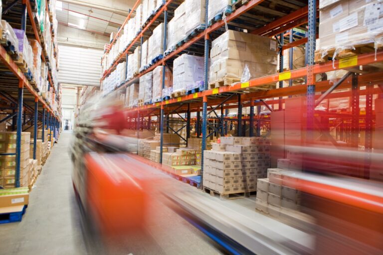 workers moving through a large company warehouse