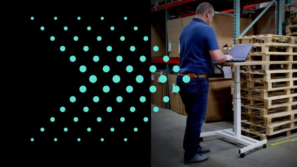 Man standing at computer in warehouse