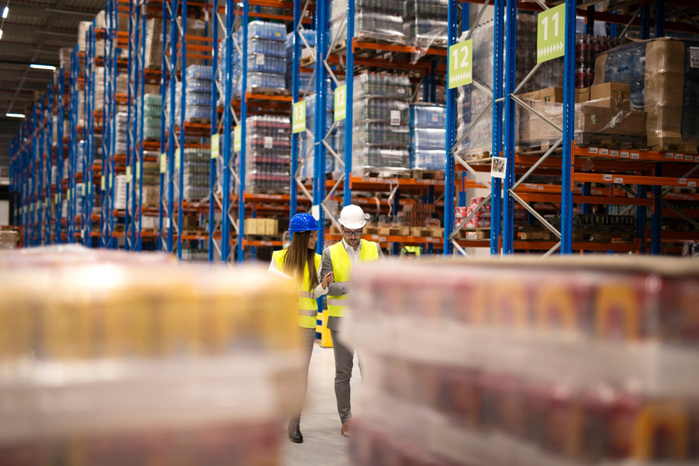 Distribution workers evaluating inventory numbers in warehouse.